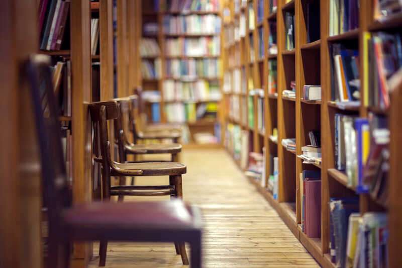 Library with books on shelf and empty chairs